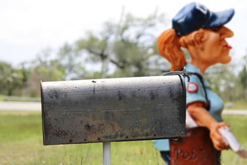 Frau wirft Briefe in einen Briefkasten