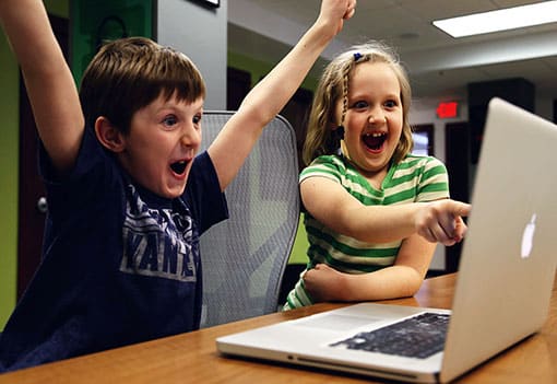 Mädchen und Junge vor dem Computer